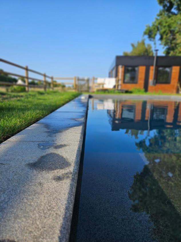 Houten huisje tussen paarden Nieuwerkerken Buitenkant foto